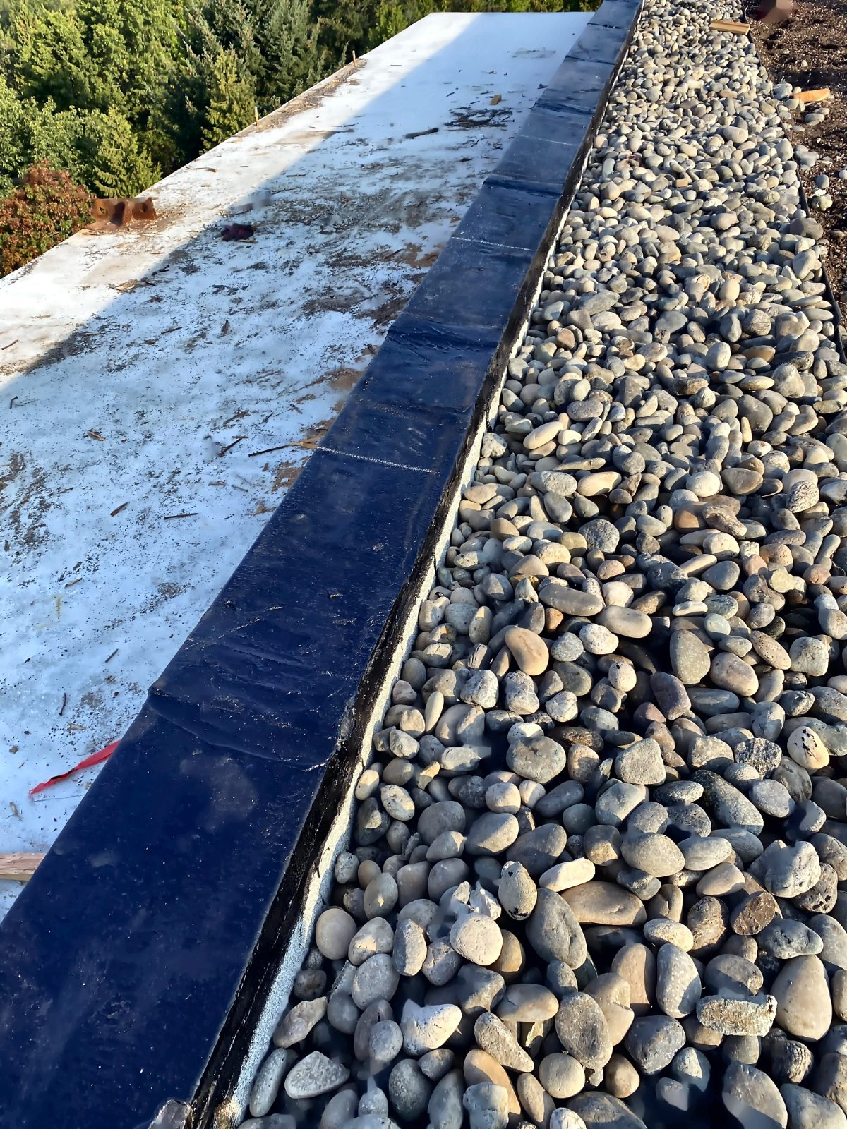 Ballasted flat roof membrane with river rock